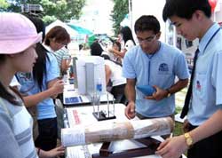 Học sinh Nguyễn Thanh Bình, lớp 10 đang giải thích nguyên lý về trọng tâm của một vật qua phần thí nghiệm lý với các bạn trẻ tham quan