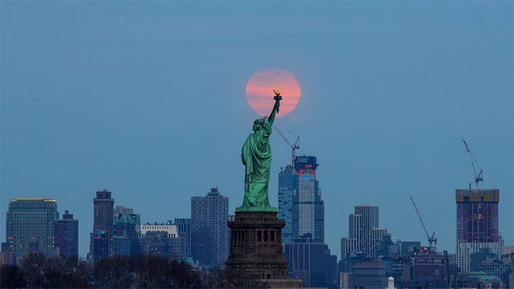 Trong góc ảnh này, bức tượng nổi tiếng Nữ thần Tự Do ở New York dường như đang quan sát Mặt Trăng mọc dần lên từ đường chân trời.