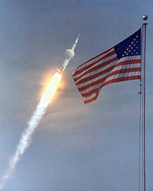 Quốc kỳ Mỹ tung bay khi tên lửa Saturn V vút lên không trung.