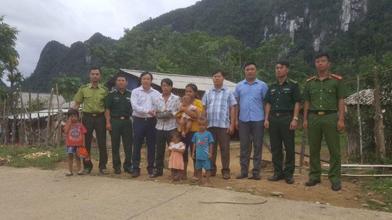 Ông Đinh Huy Trí (áo trắng) tiếp nhận bộ hàm tê giác hóa thạch từ người dân bản Yên Hợp.