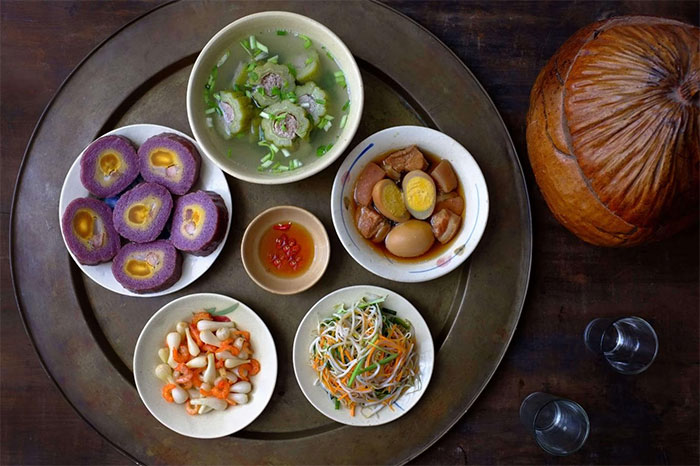 Mâm cơm Tết miền Nam có bánh Tét nhân chuối đậu, canh khổ qua, thịt kho hột vịt...