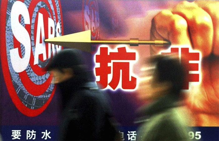 Người dân đi ngang qua một quảng cáo chống SARS ở Thượng Hải vào tháng 12/2003.