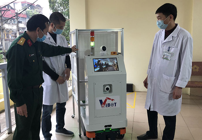 PGS.TS. Đại tá Tăng Quốc Nam, Chủ nhiệm đề tài (bìa trái) giới thiệu robot tới các bác sĩ bệnh viện Bắc Thăng Long.