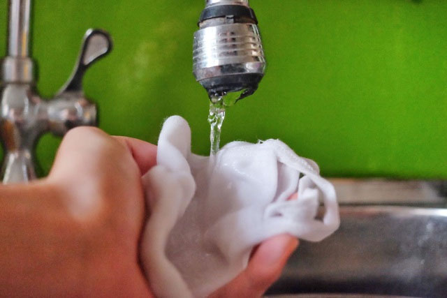 Dấp một một ít nước từ vòi hoặc chai nước khoáng lên chiếc khẩu trang