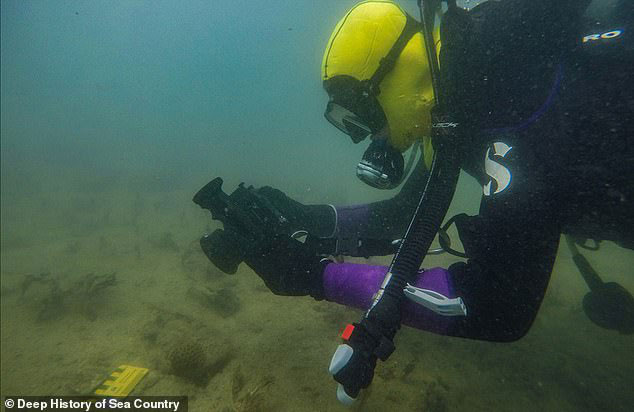 Một thợ lặn đang chụp ảnh lại cổ vật dưới 