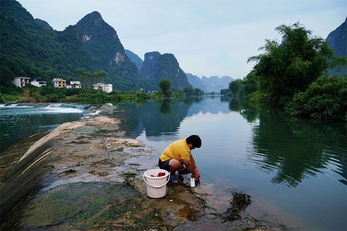 Người dân giặt quần áo tại sông Yulong, một nhánh của sông Li, tại huyện Dương Sóc ngày 17/7.