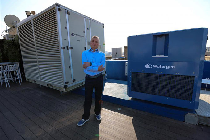 CEO Watergen Michael Mirilashvili đứng cạnh một cỗ máy chiết xuất nước từ không khí.