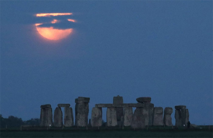 Mặt trăng tròn sau vòng tròn đá Stonehenge gần Amesbury, Anh